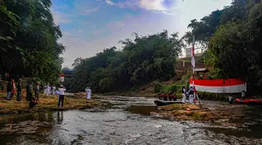 Peserta mengikuti upacara pengibaran bendera, di Sungai Ciliwung kawasan GDC, Depok, Jawa Barat, Sabtu (17/8/2024). (merdeka.com/Arie Basuki)