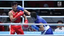 Petinju putra Indonesia, Sunan Agung Amoragam (kaus merah) mendapat pukulan Mirazizbek Mirzakhalilov (Uzbekistan) pada semifinal bantam 56kg putra Asian Games 2018 di JIEXPO Kemayoran, Jumat (31/8). Amoragam kalah 0-5. (Liputan6.com/Helmi Fithriansyah)