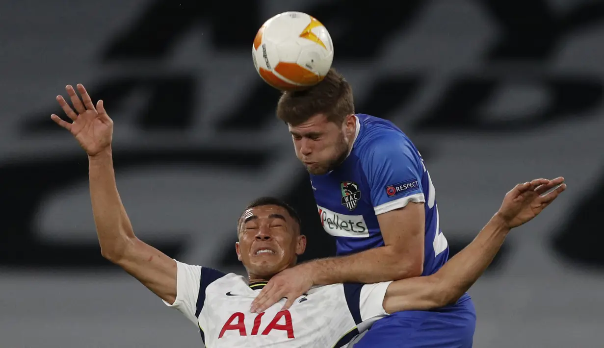 Bek Wolfsberger, Dominik Baumgartner (atas) berduel udara dengan striker Tottenham Hotspur, Carlos Vinicus dalam laga leg kedua babak 32 Besar Liga Europa 2020/21 di Tottenham Hotspur Stadium, Rabu (25/2/2021). Wolfsberger kalah 0-4 dari Tottenham. (AFP/Adrian Dennis)