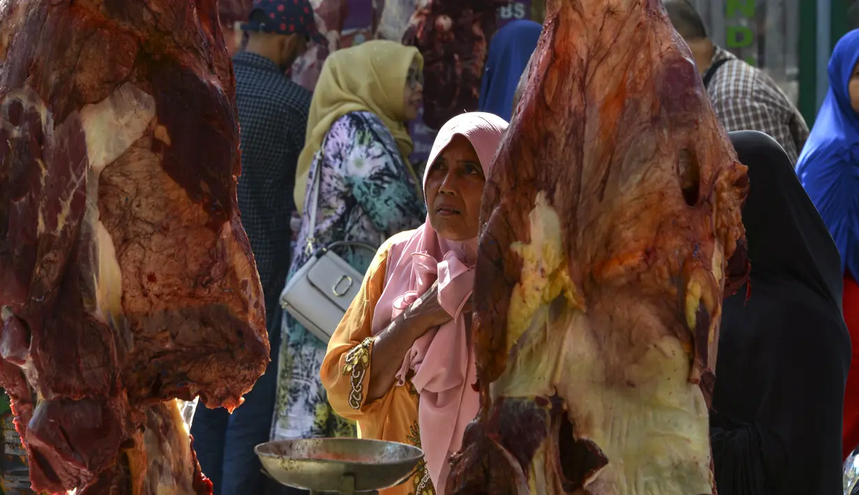 Seorang wanita Aceh berbelanja daging pada perayaan tradisi Meugang Ramadan 1440 Hijriah di pasar tradisional di Banda Aceh, 4 Mei 2019. Meugang merupakan tradisi turun temurun masyarakat Aceh dengan membeli, mengolah, hingga menyantap daging bersama keluarga. (CHAIDEER MAHYUDDIN/AFP)