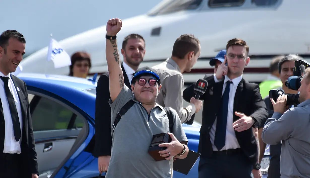 Legenda Argentina, Diego Maradona mengepalkan tangan ke udara setibanya di bandara Brest, Senin (16/7). Maradona mendarat di Belarusia untuk menjalani tugas barunya sebagai presiden klub sepak bola Dinamo Brest. (AFP PHOTO / Sergei GAPON)