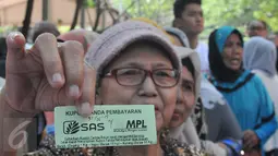Seorang warga memperlihatkan kupon tanda pembayaran untuk beras dan daging murah, Jakarta, Minggu (21/6/2015). Operasi Pasar diluncurkan Kemendag untuk membantu warga mendapatkan beras dan daging murah saat Ramadan. (Liputan6.com/Herman Zakharia)