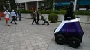 Sebuah robot berpatroli di distrik perbelanjaan dan perumahan selama uji coba di Singapura, Senin (6/9/2021). Robot otonom Xavier berpatroli di area publik untuk mencegah perilaku sosial yang buruk seperti melanggar langkah-langkah keamanan Covid-19 dan merokok di area terlarang. (ROSLAN RAHMAN/AFP)