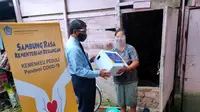 Eti Sumiati (43), warga Jalan Radial Palembang Sumsel menerima bantuan paket sembako dari program Kemenkeu Peduli Pandemi Covid-19 (Liputan6.com / Nefri Inge)