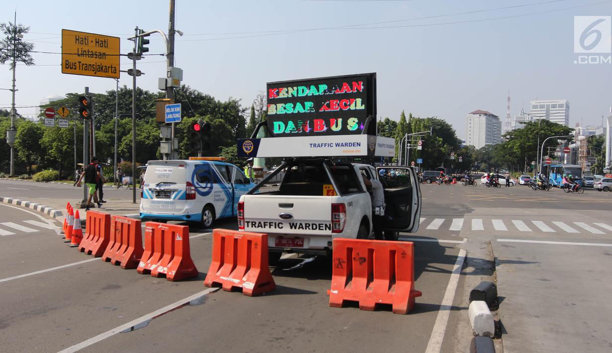 Petugas melakukan rekayasa lalu lintas imbas dari kegiatan May Day 2018 di kawasan Harmoni, Jakarta Pusat, Selasa (1/5). Rekayasa lalin diberlakukan di sejumlah titik aksi di Jakarta. (Liputan6.com/Arya Manggala)