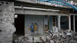 Sebuah karya seni dari seniman jalanan terkenal TvBoy dibuat pada dinding stadion pusat yang rusak akibat serangan Rusia terhadap Ukraina di Kota Irpin, Ukraina, 30 Januari 2023. Karya seni yang dibuat untuk menghormati para korban perang Rusia-Ukraina tersebut mengandung pesan kelahiran kembali dan harapan serta berharap agar konflik segera berakhir. (AP Photo/Efrem Lukatsky)