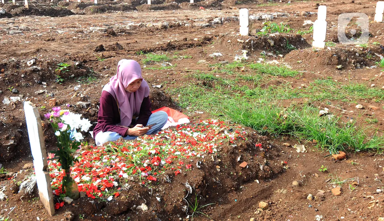 Warga melakukan ziarah makam menyambut bulan Ramadhan 1442 H di Tempat Pemakaman Umum (TPU) khusus covid-19 di Srengseng sawah 2, Jakarta Selatan, Jumat (09/04/2021). Tradisi ziarah makam dalam menyambut bulan Ramadhan setiap tahun dilakukan oleh umat Islam.
(merdeka.com/Arie Basuki)