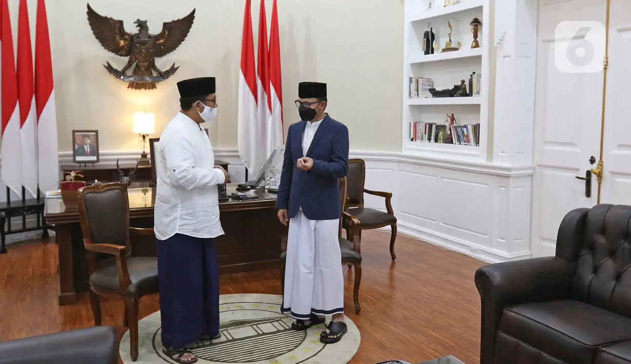 Wali Kota Bogor Bima Arya (kanan) berbincang dengan kadis PUPR Khusnul di kantornya Balai Kota Bogor, Kamis (22/04/2021). PNS di lingkungan Pemkot Bogor diwajibkan memakai pakaian ala santri setiap tanggal 22 tiap bulannya sebagai wujud penghormatan jasa para santri. (Liputan6.com/Herman Zakharia)