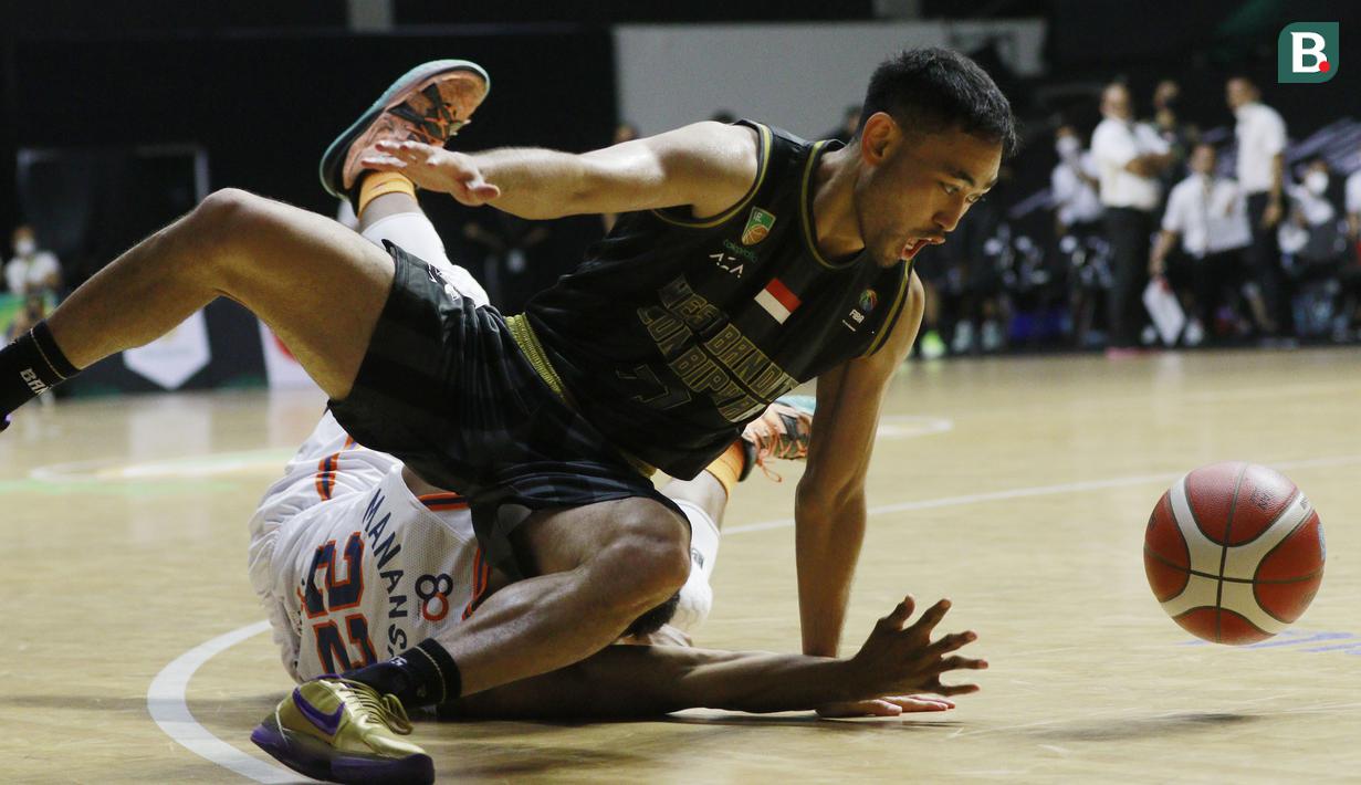 Pebasket West Bandits Solo, Widyanta Putra Teja, terjatuh saat berebut bola dengan pebasket Pelita Jaya pada laga seri I IBL 2022 di Hall Basket GBK, Jakarta, Jumat (21/01/2022). Pelita Jaya menang dengan skor 87-81. (Bola.com/M Iqbal Ichsan)