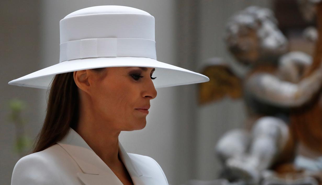 Istri Presiden AS Donald Trump, Melania Trump mengenakan topi saat mendampingi istri Presiden Prancis Brigitte Macron di National Gallery of Art di Washington (24/4). (AP/Jacquelyn Martin)