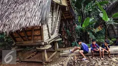 Anak-anak Suku Baduy berpakaian kaos kesebelasan duduk santai di halaman Kampung Kadung Jangkung, Kabupaten Lebak, Banten (11/05). (Liputan6.com/Fery Pradolo)