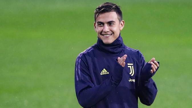 Striker Juventus, Paulo Dybala tersenyum sambil bertepuk tangan selama latihan tim di Contassina, Turin, Italia (6/11). Di pertemuan pertama Juventus menang tipis atas Manchester United 1-0 berkat Gol striker Paulo Dybala. (AFP Photo/Isabella Bonotto)