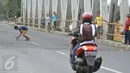 Seorang bocah mengambil uang yang dilempar pengguna jalan di Jembatan Cikalong, Jawa Barat, Sabtu (2/7). Memasuki mudik Lebaran, jumlah pencari uang sedekah di kawasan itu meningkat dibanding hari biasa (Liputan6.com/Gempur M Surya)