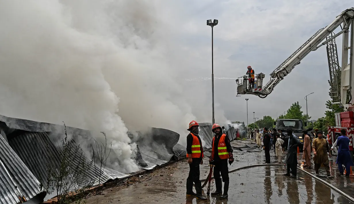 Petugas pemadam terus berupaya untuk melakukan pemadaman dan pendinginan di kawasan tersebut. (Aamir Qureshi/AFP)