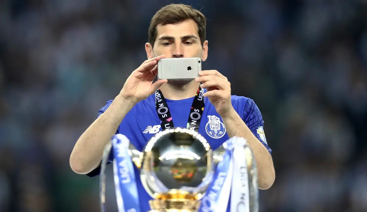 Kiper Porto, Iker Casillas mengabadikan trofi Liga Portugal pertandingan melawan Feirense di stadion Dragao (6/5). Porto memastikan diri keluar sebagai juara Liga Portugal menyusul hasil imbang Sporting CP dan Benfica. (AP Photo/Luis Viera)
