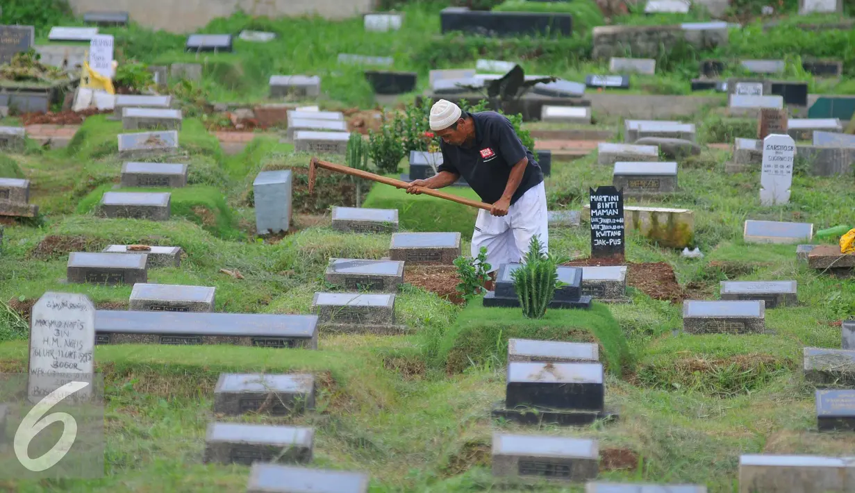 Pekerja membersihkan area makam di TPU Karet Bivak, Jakarta (2/2). Dinas Pertamanan dan Pemakaman telah menerapkan sistem online dalam pelayanan pemakaman di Ibu kota dengan alamat situs pertamananpemakaman.jakarta.go.id. (Liputan6.com/Gempur M Surya)