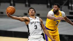 Pebasket Los Angeles Lakers, Anthony Davis, berebut bola dengan pebasket San Antonio Spurs, Keldon Johnson, pada laga NBA di AT&T Center, Kamis (31/12/2020). LA Lakers menang dengan skor 121-107. (AP/Eric Gay)