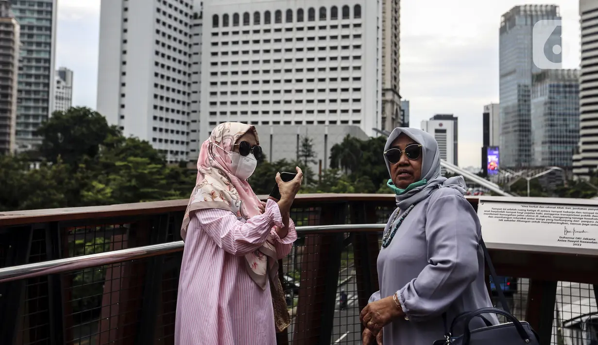 Warga mengoperasikan ponsel saat berswafoto di Jembatan Penyeberangan Orang (JPO) Pinisi, Jalan Jenderal Sudirman, Karet, Jakarta, Selasa (15/3/2022). Keberadaan JPO Pinisi langsung disambut baik oleh warga dengan ramai-ramai berkunjung untuk sekadar melakukan swafoto. (Liputan6.com/Johan Tallo)