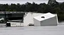 Sebuah kontainer mengapung saat air banjir yang naik membanjiri area komersial akibat hujan lebat di pinggiran barat daya Camden, Sydney, Australia, Selasa (8/3/2022). (Muhammad FAROOQ/AFP)