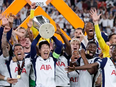 Pemain depan Tottenham Hotspur asal Korea Selatan, Son Heung-min mengangkat trofi Liga Europa saat merayakan kemenangan bersama rekan setimnya usai pertandingan final melawan Manchester United di stadion San Mames, Bilbao, pada 21 Mei 2025 waktu setempat atau Kamis (22/5) dini hari WIB. (Thomas COEX/AFP)