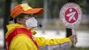 <p>Seorang penjaga persimpangan yang mengenakan masker berdiri di persimpangan di Beijing, Rabu (11/5/2022). Shanghai pada Rabu menegaskan kembali akan mempertahankan pendekatan &ldquo;nol-COVID&rdquo; pengendalian pandemi, sehari setelah kepala Organisasi Kesehatan Dunia (WHO) menyatakan kebijakan itu tidak berkelanjutan dan mendesak China mengubah strategi. (AP Photo/Mark Schiefelbein)</p>