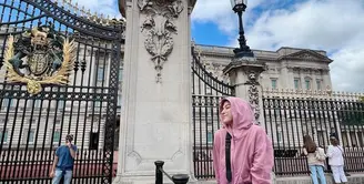 Seperti saat berpose di depan istana Buckingham ini. Perempuan 30 tahun itu tampil chic gantikan hijab dengan hoodie warna pink. (Instagram/ninazatulini22).