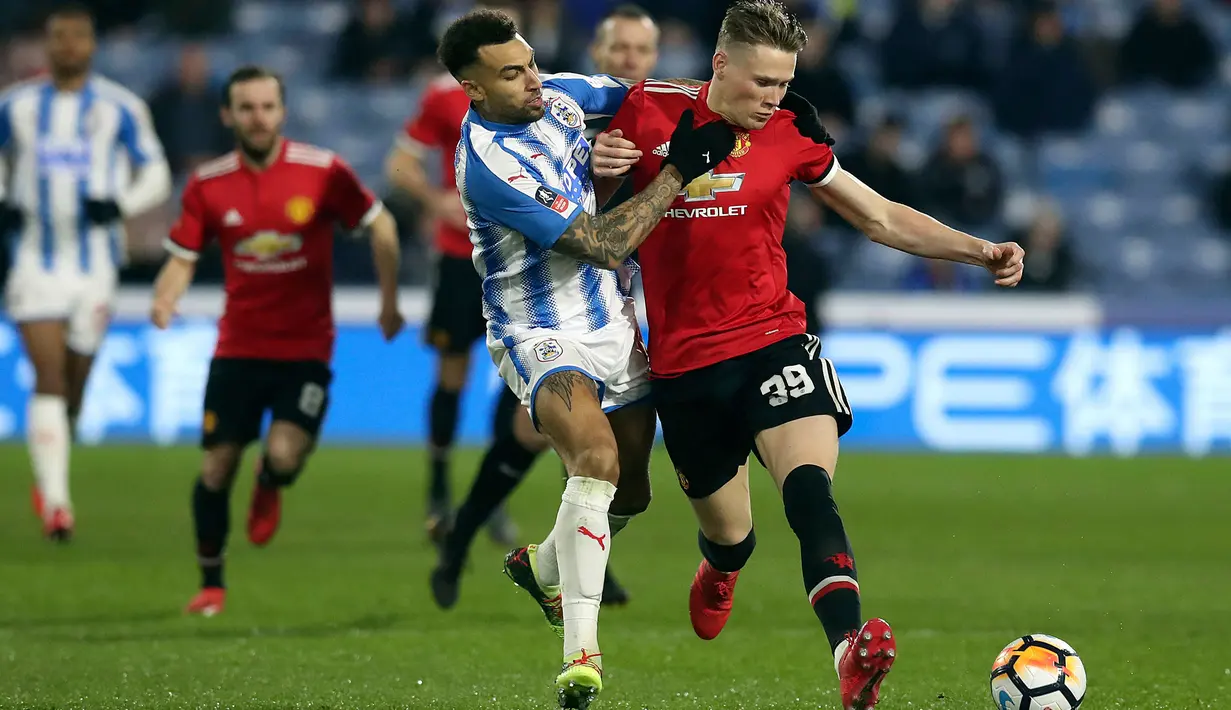 Bek Huddersfield Town, Danny Williams berebut bola dengan pemain Manchester United, Scott McTominay pada pertandingan putaran kelima Piala FA di John Smith's Stadium, Minggu (18/2). MU melaju ke perempatfinal setelah menang 2-0. (Martin Rickett/PA via AP)
