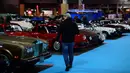 Seorang lelaki memandangi sebuah mobil tua yang ditampilkan selama pameran mobil klasik Retromobile di Porte de Versailles, di Paris (4/2/2020). Retromobile berlangsung dari 5 Februari hingga 9 Februari 2020. (AFP Photo/Martin Bureau)