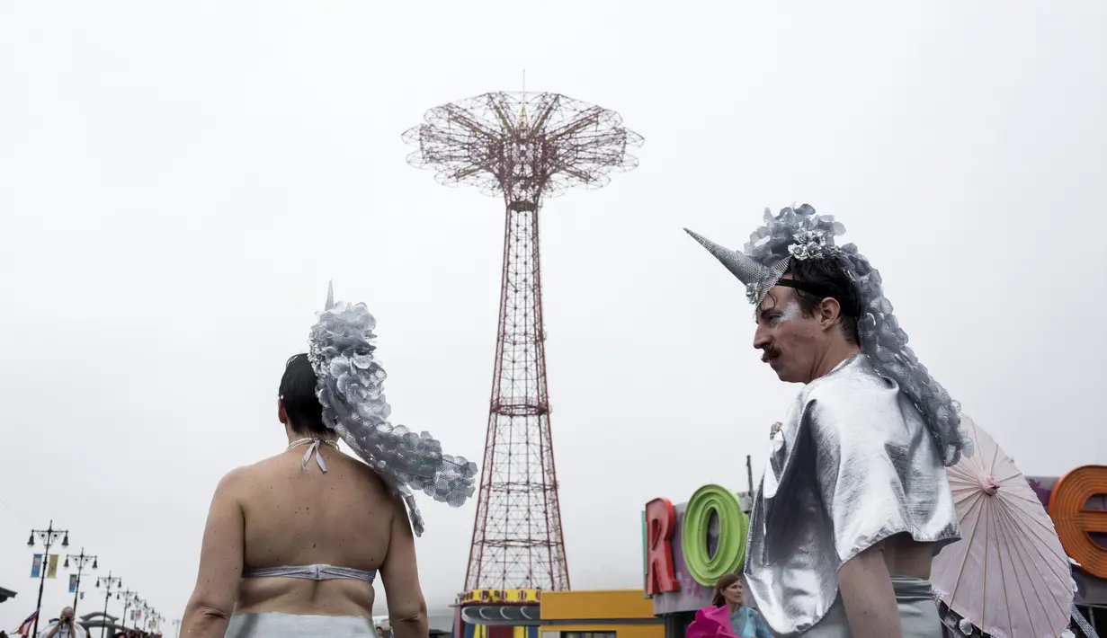 Dua orang pengunjung mengenakan kostum bertema putri duyung mengikuti Parade Mermaid 2017 di Coney Island, New York City (17/6). Acara yang digelar setiap tahun ini menarik jumlah peserta dan wisatawan. (Alex Wroblewski/Getty Images/AFP)