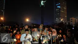 Aksi simpatik dan doa bersama untuk Angeline dengan menyalakan lilin di Bundaran HI, Jakarta, Kamis (11/6/2015). Mereka meminta pemerintah bersikap tegas kepada pelaku kekerasan anak. (Liputan6.com/Johan Tallo)