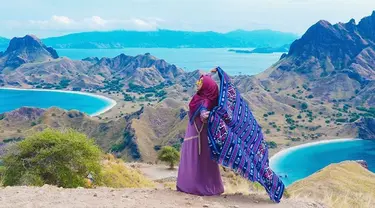 Perempuan yang memiliki channel youtube dengan subscriber 16,8 juta sampai sekarang ini tampak bahagia saat liburan di Labuan Bajo. Menggunakan pakaian serba ungu dan merah, ia memegang kain khas nusantara dengan lepas. (Liputan6.com/IG/@riaricis1795)