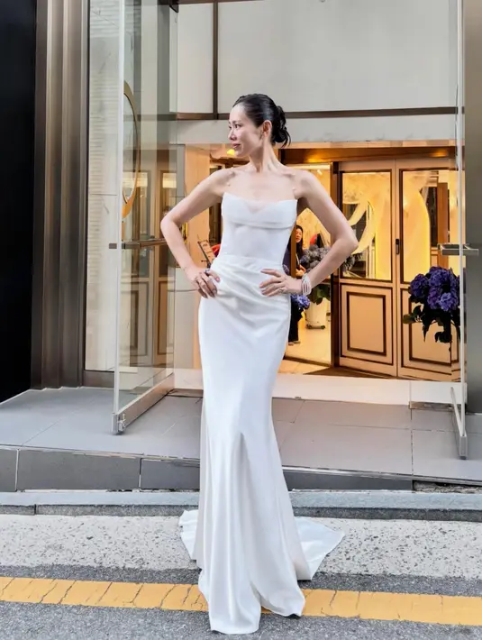 Son Ye Jin mengenakan long dress putih strap mutiara dari New White. [@yejinhand]