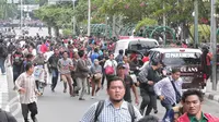 Sejumlah warga lari berhamburan seusai mendengar isu bom yang akan kembali meledak pasca terjadinya ledakan yang terjadi di Pos polisi dekat pusat perbelanjaan Sarinah, Jalan Thamrin, Jakarta, Kamis (14/1). (Liputan6.com/Angga Yuniar)