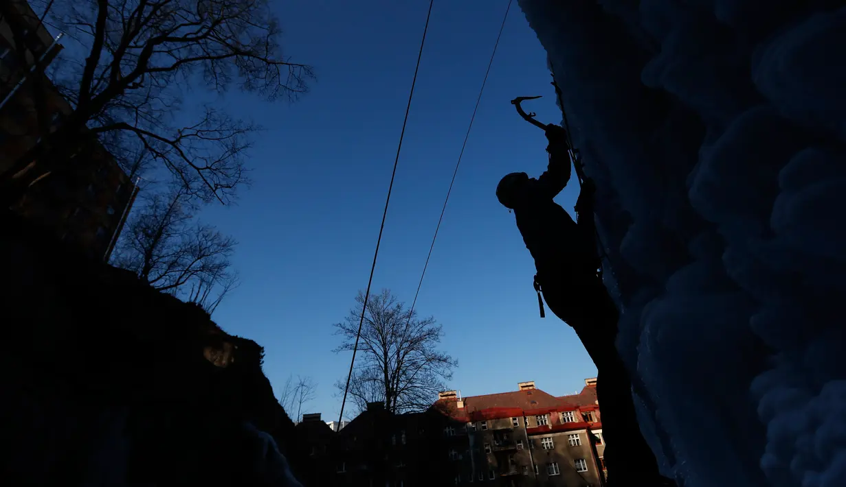 Seorang pria memanjat menggunakan alat di dinding tebing es buatan di Liberec, Republik Ceko, Kamis (1/3). Meski buatan, tidak sembarang orang bisa menaklukkan tebing es tersebut. (AP Photo/Petr David Josek)