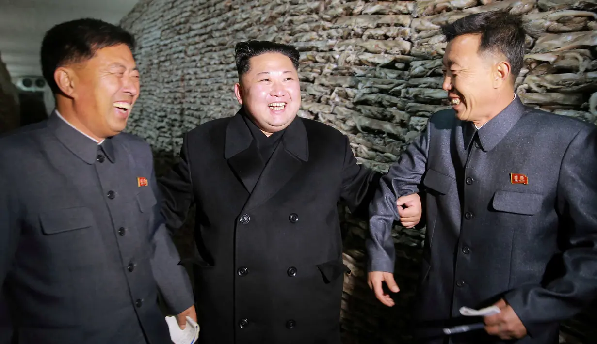Pemimpin Korea Utara, Kim Jong-un (tengah) berbincang dengan pejabat yang mendampinginya saat mengunjungi stasiun perikanan di Pyongyang, Kamis (17/11). Kim Jong-un mengaku senang dengan hasil tangkapan ikan yang melimpah. (REUTERS/KCNA)