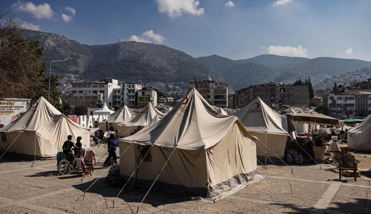 Sejumlah tenda berdiri di sebuah kamp pengungsian di Antakya, Turki Selatan, pada 22 Februari 2023. Gempa berkekuatan 6,4 magnitudo kembali mengguncang provinsi selatan Turki, Hatay, dan Suriah Utara, menewaskan enam orang dan memicu kepanikan baru setelah gempa besar pada 6 Februari lalu yang menewaskan hampir 45.000 orang di kedua negara tersebut. (Sameer Al-DOUMY/AFP)