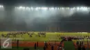 Petugas kepolisian menguasai lapangan setelah terlibat bentrok dengan suporter saat laga Persija melawan Sriwijaya FC di Stadion GBK Jakarta, Jumat (24/6). Laga dihentikan di menit 81.(Liputan6.com/Helmi Fithriansyah)