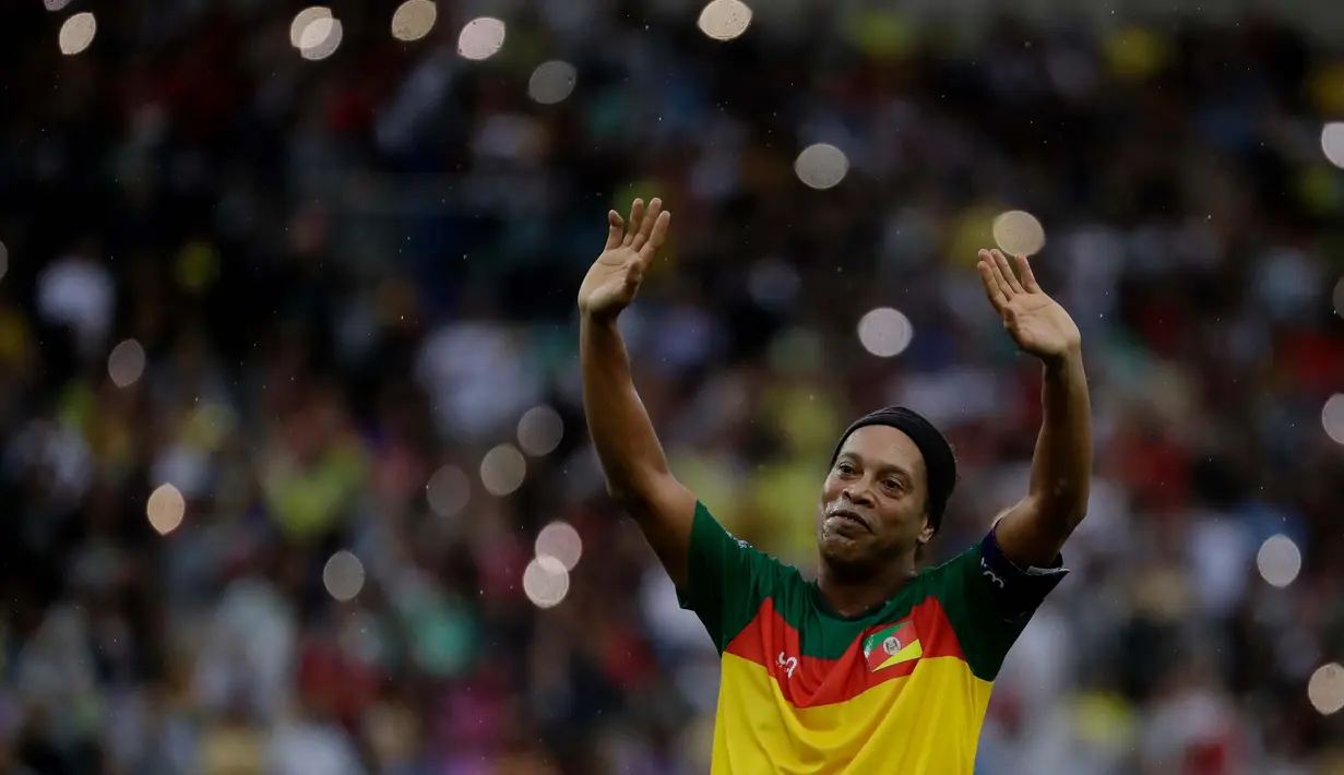 Ronaldinho Gaucho merayakan golnya dalam pertandingan sepak bola eksibisi untuk menggalang dana bagi para korban banjir yang melanda Brasil Selatan, di stadion Maracana, Rio de Janeiro, Minggu, 26 Mei 2024. (AP Photo/Bruna Prado)