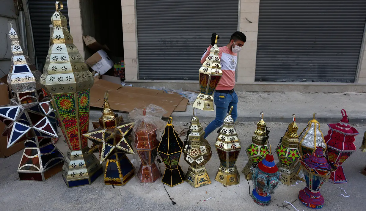 Pedagang Palestina menjual lentera Ramadan tradisional di sebuah pasar di Kota Nablus, Tepi Barat (19/4/2020). Jelang Ramadan, warga Palestina membeli lentera beraneka warna, yang dikenal sebagai fanoos dalam bahasa Arab, untuk anak-anak mereka atau sebagai hiasan di rumah. (Xinhua/Rizek Abdeljawad)