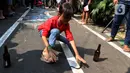 Seorang anak berusaha menangkap belut untuk dimasukkan ke dalam botol saat mengikuti lomba menyambut HUT ke-78 RI. (Liputan6.com/Angga Yuniar)
