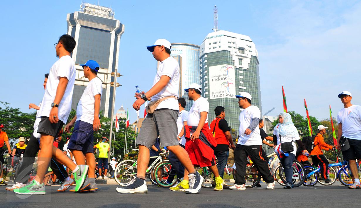 Para peserta Fun Walk memperingati ke-70 Hari Bakti Postel menuju bundaran HI dengan berjalan santai, Jakarta, Minggu (8/11/2015). Acara ini digelar Kemkominfo untuk mengenang jasa para pahlawan telekomunikasi Indonesia. (Liputan6.com/Faisal R Syam) 
