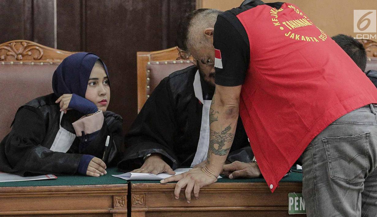 Tio Pakusadewo berdiskusi dengan kuasa hukumnya disela sidang pembacaaan dakwaan kasus penyalahgunaan narkoba di PN Jakarta Selatan, Senin (30/4). Sidang lanjutan dengan menghadirkan sejumlah saksi digelar pada 7 Mei 2018. (Liputan6.com/Faizal Fanani)