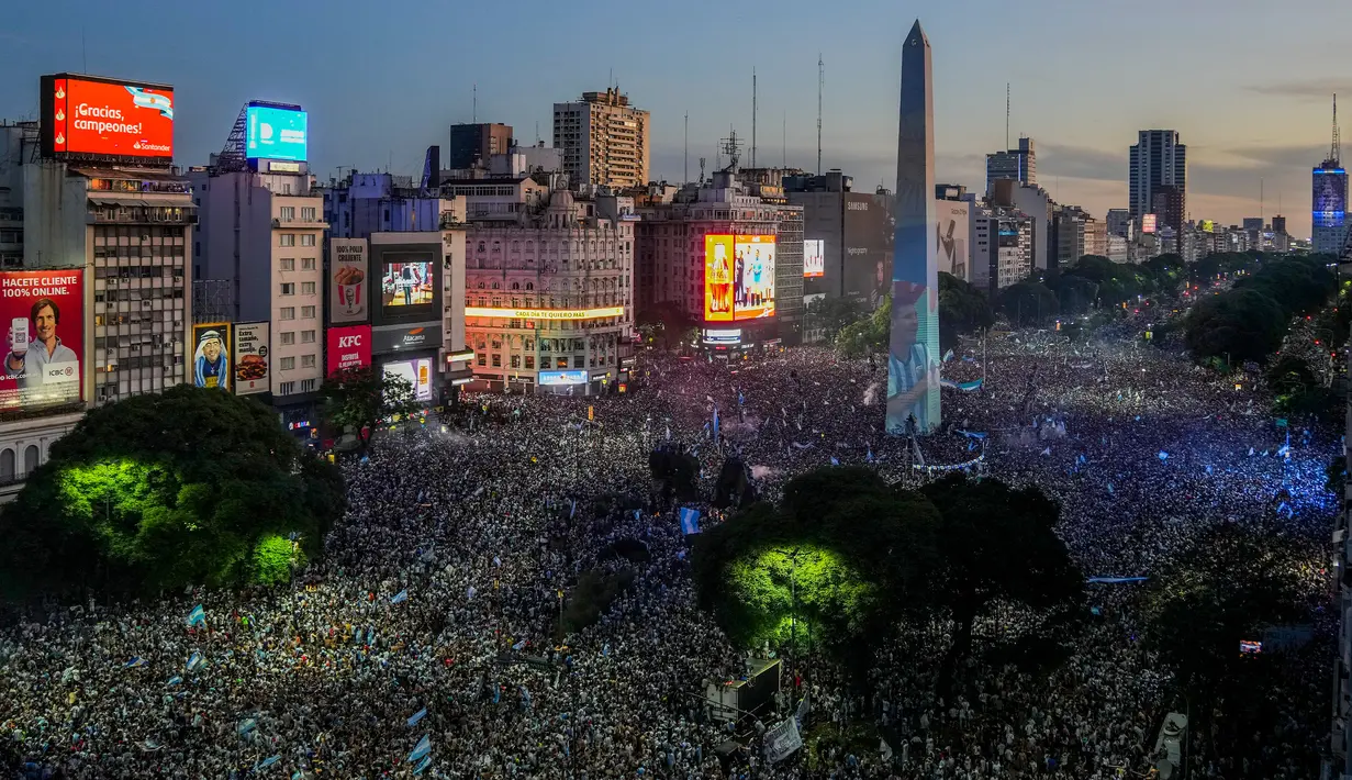 Suporter turun ke Obelisk untuk merayakan kemenangan timnas sepak bola Argentina atas Prancis pada pertandingan final Piala Dunia Qatar 2022 di Buenos Aires, Argentina, 18 Desember 2022. Argentina menang 4-2 dalam drama adu penalti setelah pertandingan berakhir imbang dengan skor 3-3. (AP Photo/Matilde Campodonico)