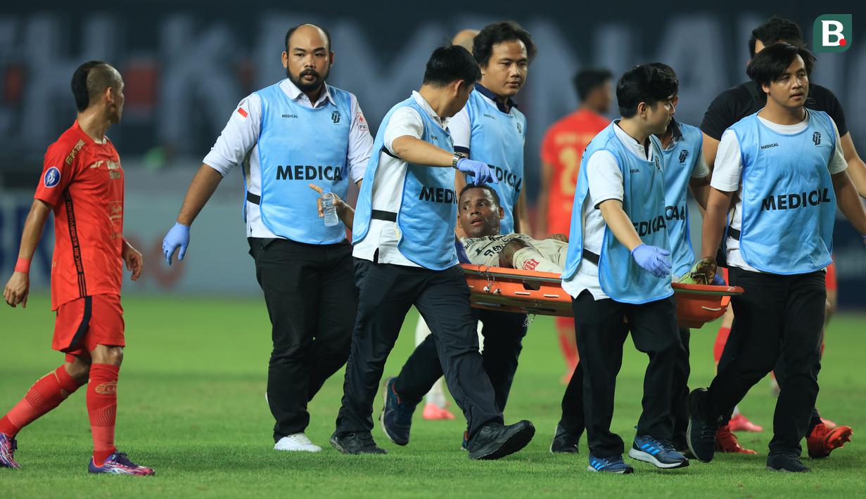 Pemain Bali United, Eber Bessa, ditandu keluar lapangan saat melawan Persija Jakarta pada laga pekan ke-13 BRI Liga 1 2023/2024 di Stadion Patriot Candrabhaga, Bekasi, Minggu (24/9/2023). (Bola.com/M Iqbal Ichsan)