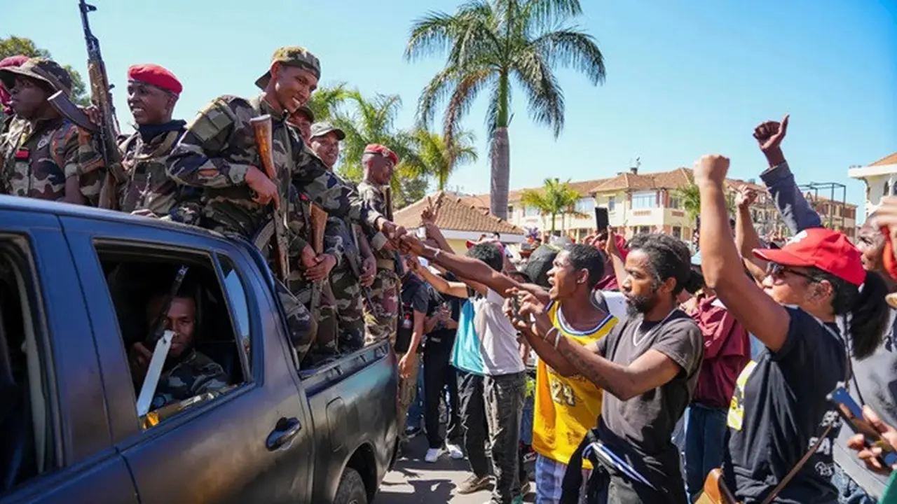 Tentara disambut oleh warga yang berkumpul dalam sebuah upacara untuk mengenang para demonstran yang tewas dalam aksi protes anti-pemerintah baru-baru ini di Antananarivo, Madagaskar, pada Minggu, (12/10/2025).