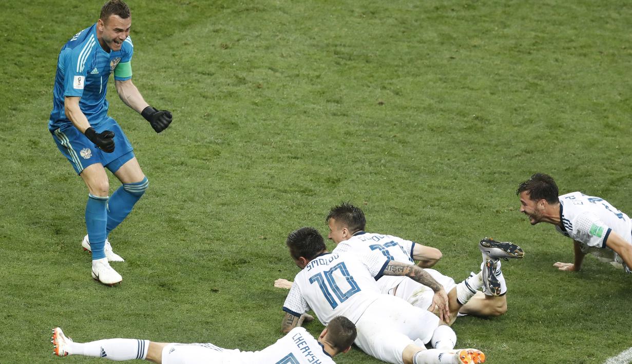Para pemain Rusia menghampiri kiper, Igor Akinfeev (kiri) usai menahan tendangan penalti pemain Spanyol pada laga 16 besar Piala Dunia 2018 di  Luzhniki Stadium, Moskow, Rusia, (1/7/2018). Rusia menang penalti atas Spanyol Spain 4-3. (AP/David Vincent)