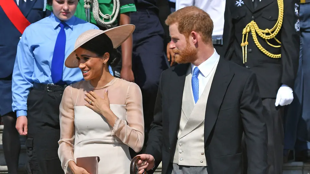 Duke dan Duchess of Sussex, Pangeran Harry dan Meghan Markle menghadiri pesta kebun Istana Buckingham di London, Selasa (22/5). Meghan juga memakai stocking warna kulit, mengikuti cara berbusana Putri Inggris lainnya. (Dominic Lipinski/Pool Photo via AP)
