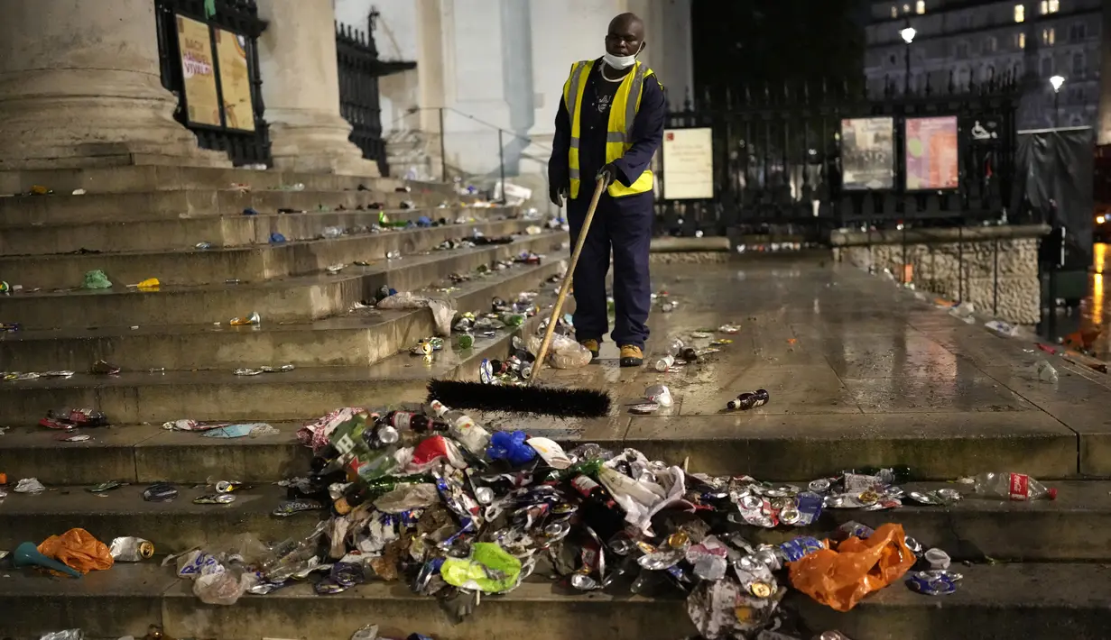 Seorang pekerja membersihkan sampah dari tangga di pusat kota London, setelah Italia mengalahkan Inggris dalam perebutan gelar juara EURO 2020, pada Minggu (11/7/2021). Usai pertandingan, jalan-jalan di London juga dipenuhi sampah. (AP Photo/Matt Dunham)