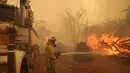 Seorang petugas pemadam kebakaran memadamkan kobaran api di dekat Wooroloo, di Perth, Australia, Selasa (2/1/2021). Kebakaran hutan tak terkendali di sebuah wilayah di sebelah timur laut Perth telah menghancurkan puluhan rumah dan kemungkinan mengancam lebih banyak lagi. (Evan Collis/DFES via AP)