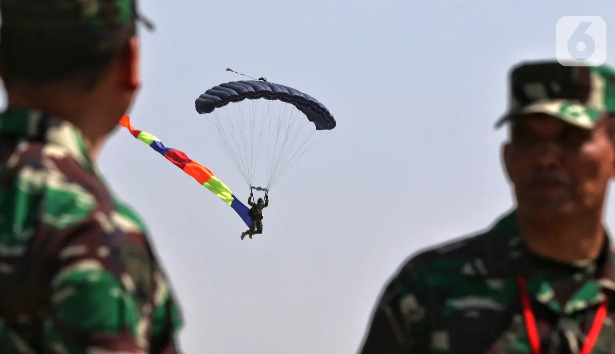 Prajurit TNI melakukan atraksi terjun payung pada perayaan HUT ke-74 TNI di Taxy Way Echo Lanud Halim Perdanakusuma, Jakarta Timur, Sabtu (5/10/2019). Selain terjun payung, HUT ke-74 TNI juga menampilkan atraksi bela diri prajurit. (Liputan6.com/JohanTallo)